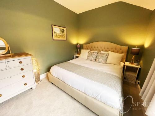 1 dormitorio con cama blanca y pared verde en Sunnybank - Traditional 3 bedroom cottage en Lincolnshire