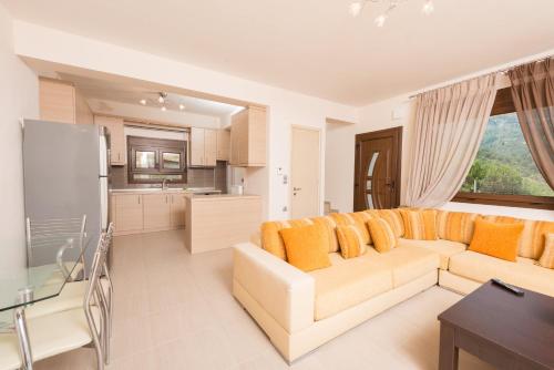 a living room with a couch and a kitchen at Vila Mond Sea View Apartments in Kinira