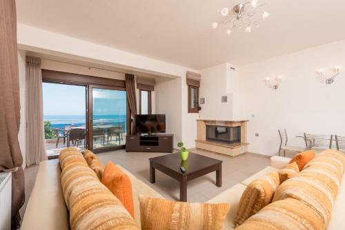 a living room with a large couch and a fireplace at Vila Mond Sea View Apartments in Kinira