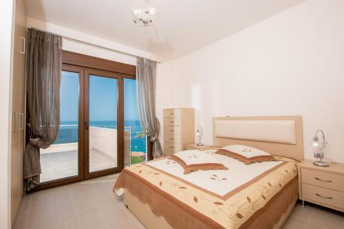 1 dormitorio con 1 cama y vistas al océano en Vila Mond Sea View Apartments en Kinira