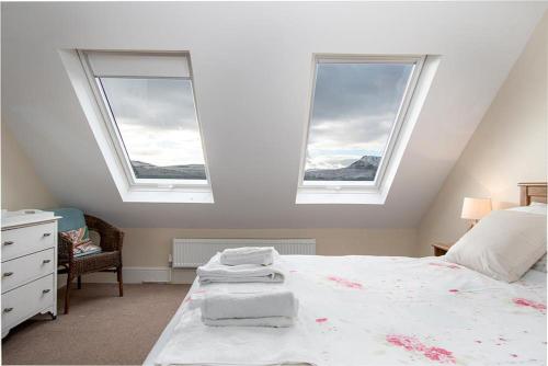 una camera da letto con due finestre e un letto con lenzuola bianche di The Barn a Bala