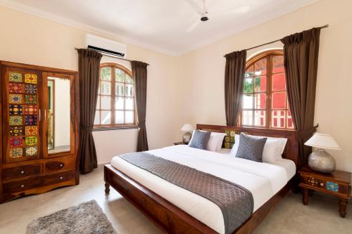 a bedroom with a large bed and two windows at Casa De Monique in Pilerne