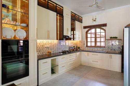 a kitchen with white cabinets and black counter tops at Casa De Monique in Pilerne