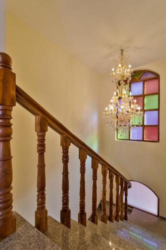 a staircase with a chandelier and a stained glass window at Casa De Monique in Pilerne