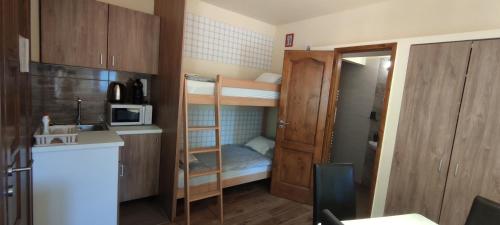 a small room with bunk beds and a kitchen at Natura Panzió Szilvásvárad in Szilvásvárad