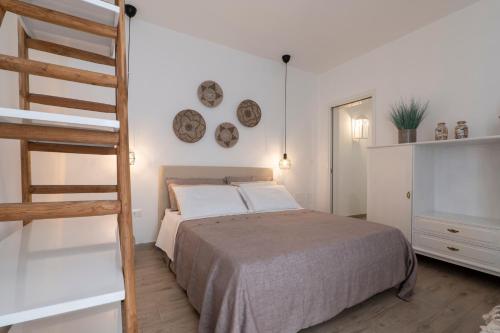 een slaapkamer met een bed en een ladder en borden aan de muur bij LIBERTY in Torre San Giovanni Ugento
