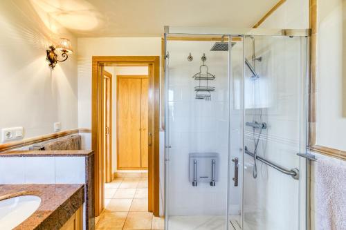 a bathroom with a glass shower and a sink at Luxury Golf Villa Torremirona in Navata