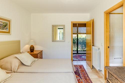 a bedroom with two beds and a door to a balcony at Luxury Golf Villa Torremirona in Navata