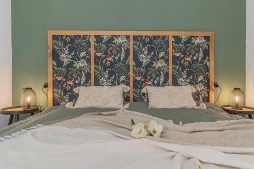 a large bed with two pillows and flowers on it at Varenna Wanderlust in Perledo