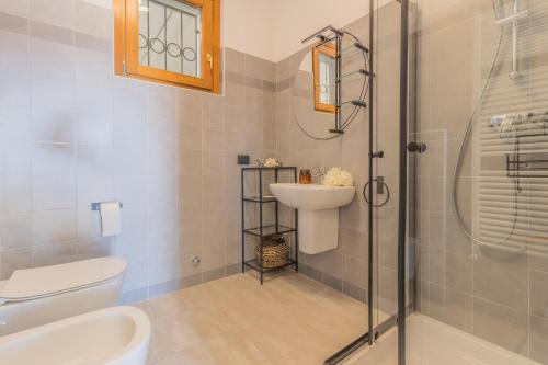 a bathroom with a toilet and a sink and a shower at Varenna Wanderlust in Perledo