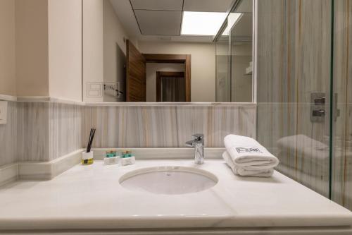 a bathroom with a sink and a mirror at BiBo Suites Real Chancilleria in Granada