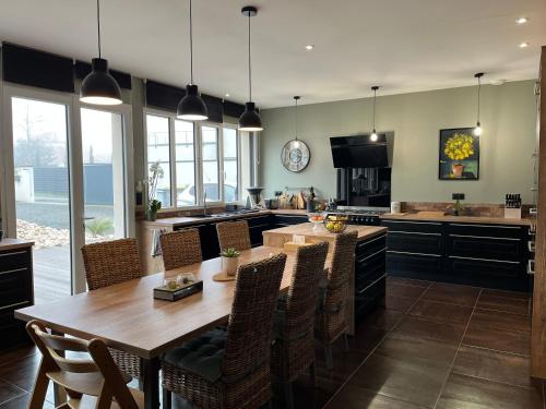 une grande cuisine avec une table et des chaises en bois dans l'établissement Le Paddock - 24h Le Mans - luxueuse - 8 pers - Venir rêver au Mans, à Changé
