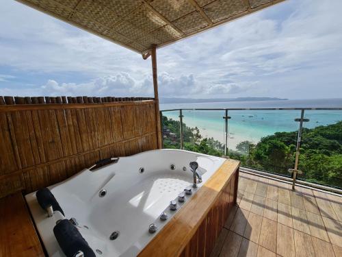 a bath tub in a room with a view of the ocean at Boracay Amor Apartment in Boracay