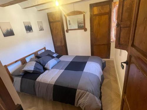 a bedroom with a large bed with blue pillows at Acogedora casa con patio-parking in Albarracín