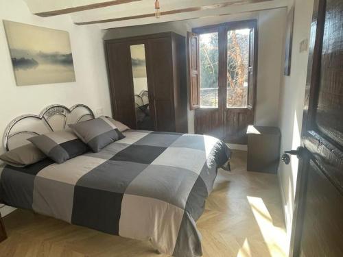 a bedroom with a black and white bed and a window at Acogedora casa con patio-parking in Albarracín