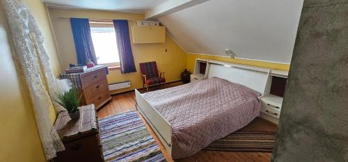ein Schlafzimmer mit einem Bett, einer Kommode und einem Fenster in der Unterkunft Holiday home among the pearls of Norway in Stranda