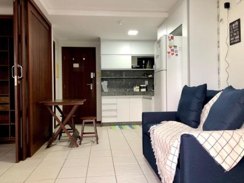 a living room with a blue couch and a kitchen at Blue Marlin Cotovelo - Vista Vale - Reformado in Parnamirim