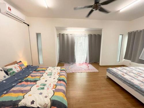 a bedroom with two beds and a ceiling fan at Homestay Balik Pulau 2.0 3BedRoom in Balik Pulau