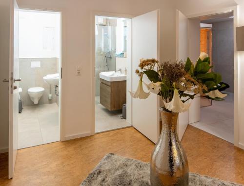 un vaso pieno di fiori su un tavolo in un bagno di Romantik Hotel Landhaus Biewald a Gottinga