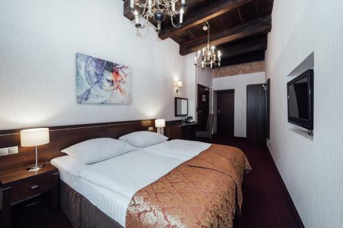 1 dormitorio con 1 cama grande y TV en Hotel Rezydent, en Cracovia