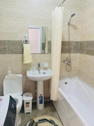 W łazience znajduje się umywalka, toaleta i wanna. w obiekcie - Enjoy Cozy Apartment, Close To City Center - w Taszkiencie