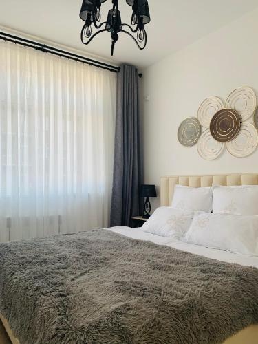 sypialnia z dużym łóżkiem i żyrandolem w obiekcie - Enjoy Cozy Apartment, Close To City Center - w Taszkiencie