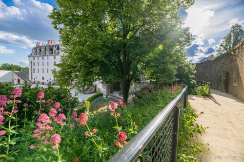 a garden with flowers and a castle in the background at Cerise Nantes Atlantis in Saint-Herblain