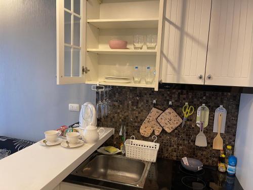 a kitchen with white cabinets and a sink at The Patio bangsaen miracle Seaview in Ban Bang Saen (1)