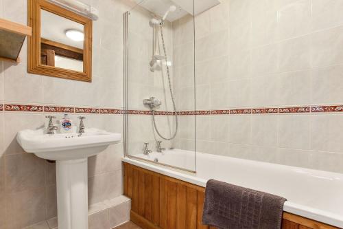 un bagno con lavandino, doccia e vasca di The Coppermines Mountain Cottages Sawyers, Carpenters, Millrace, Pelton Wheel, Sleeps 22 a Coniston