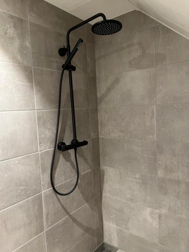 a shower with a shower head in a bathroom at Ny og moderne 2-roms leilighet in Bodø
