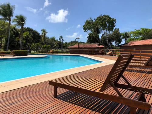 a wooden deck with a bench next to a swimming pool at Blue Marlin Cotovelo - Vista Vale - Reformado in Parnamirim