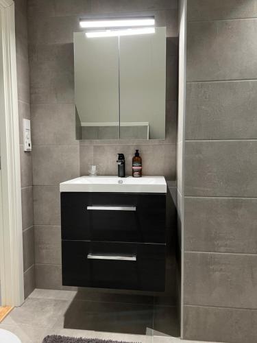 W łazience znajduje się umywalka i lustro. w obiekcie Ny og moderne 2-roms leilighet w mieście Bodø