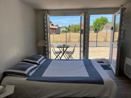 a bedroom with a bed and a sliding glass door at Tours, Touraine et Chateaux de la Loire in Fondettes