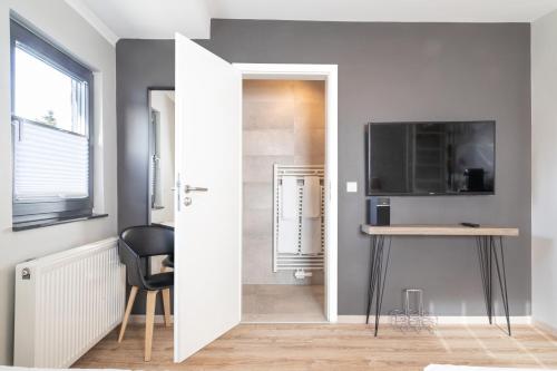 a room with a desk and a television and a door at NürbLife Hotel in Nürburg