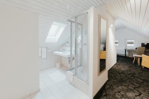 bagno bianco con lavandino e specchio di Gartenhaus by Ochsen Lenzburg a Lenzburg