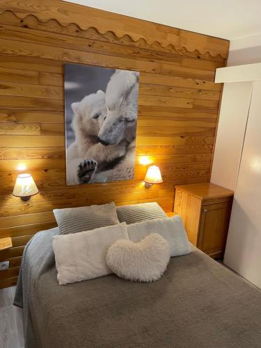 a bedroom with a bed with a picture of two polar bears at Appartement lumineux aux pieds des pistes in Saint-François-Longchamp