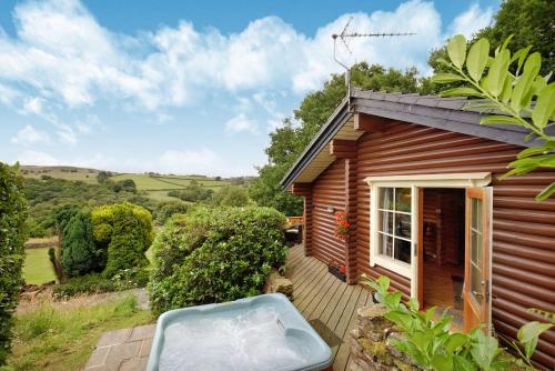 una piccola casa di legno con una panchina accanto di Faweather Grange a Bingley