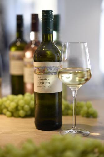 a bottle of white wine next to a glass of wine at Hästens Boutique Biohotel - chez Douverne in Sommerach