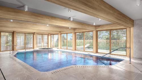uma grande piscina com janelas de vidro numa casa em Arber Resort Železná Ruda em Železná Ruda