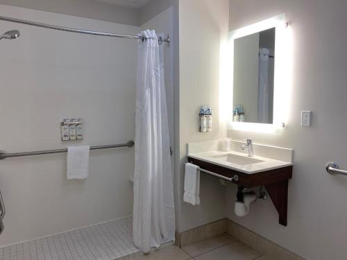 a bathroom with a sink and a shower with a mirror at Holiday Inn Express & Suites - Courtenay - Comox by IHG in Courtenay