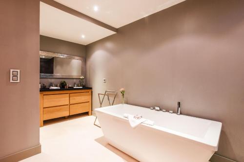ein Bad mit einer großen weißen Badewanne in einem Zimmer in der Unterkunft VILLA HESPERIDES VI4337 By Riviera Holiday Homes in Nizza