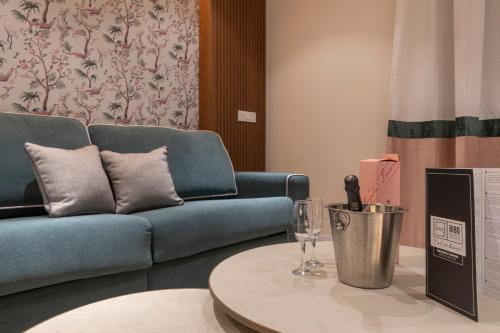 a living room with a blue couch and a table at BiBo Suites Real Chancilleria in Granada
