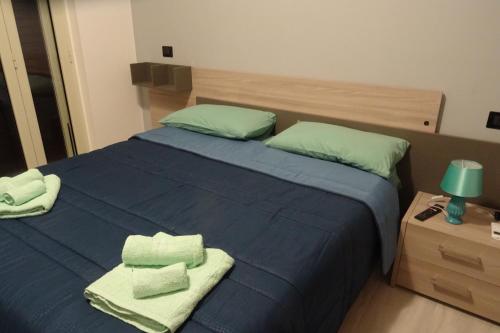 Un dormitorio con una cama azul con toallas. en B&B Alba Chiara, en Paola