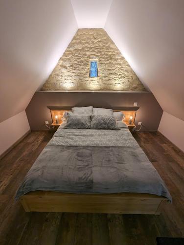 - une chambre mansardée avec un grand lit dans l'établissement Déliv'Love, à Douvres-la-Délivrande