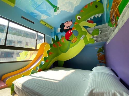 a childs bedroom with a dinosaur mural on the wall at Kaohsiung High Fun Hostel in Kaohsiung