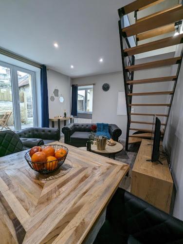 - un salon avec un bol de fruits sur une table en bois dans l'établissement Déliv'Love, à Douvres-la-Délivrande