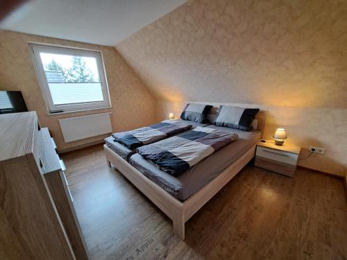 Ferienwohnung في Neukirchen: غرفة نوم بسرير كبير ونافذة