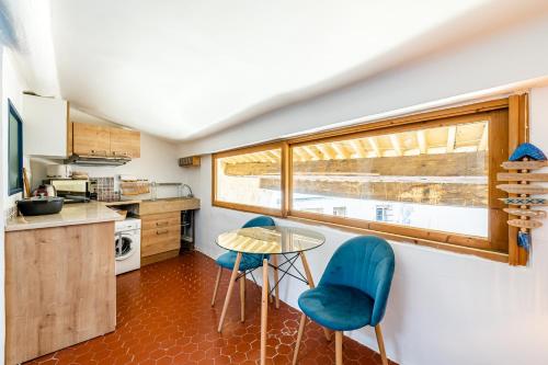 - une cuisine avec deux chaises bleues et une table dans l'établissement Petit Nid par Dodo-à-Cassis, à Cassis