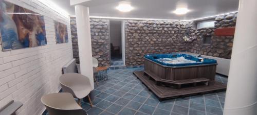 a bathroom with a blue tub in a room at Natura Panzió Szilvásvárad in Szilvásvárad