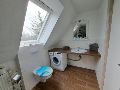 a bathroom with a sink and a washing machine at Ferienwohnung in Neukirchen
